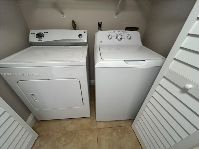 clothes washing area with light tile patterned floors and independent washer and dryer