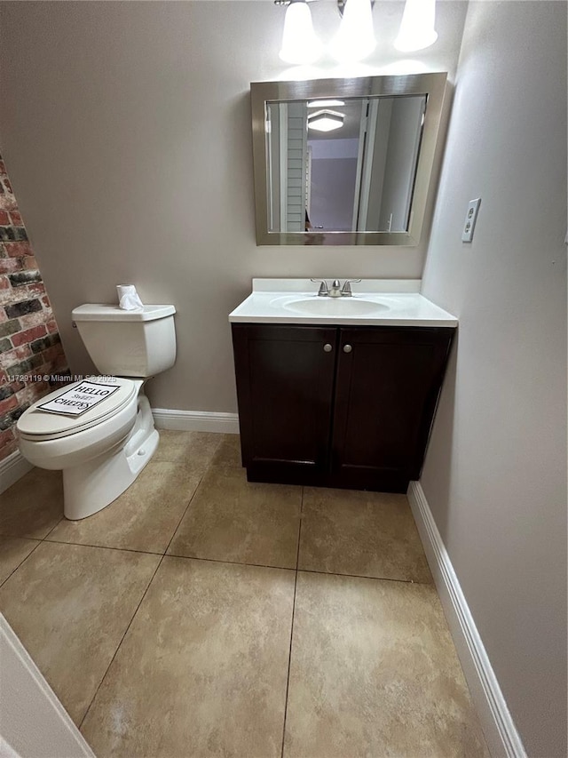 bathroom with toilet, tile patterned flooring, and vanity