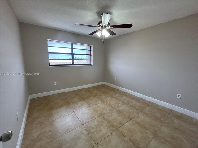 tiled empty room with a textured ceiling and ceiling fan