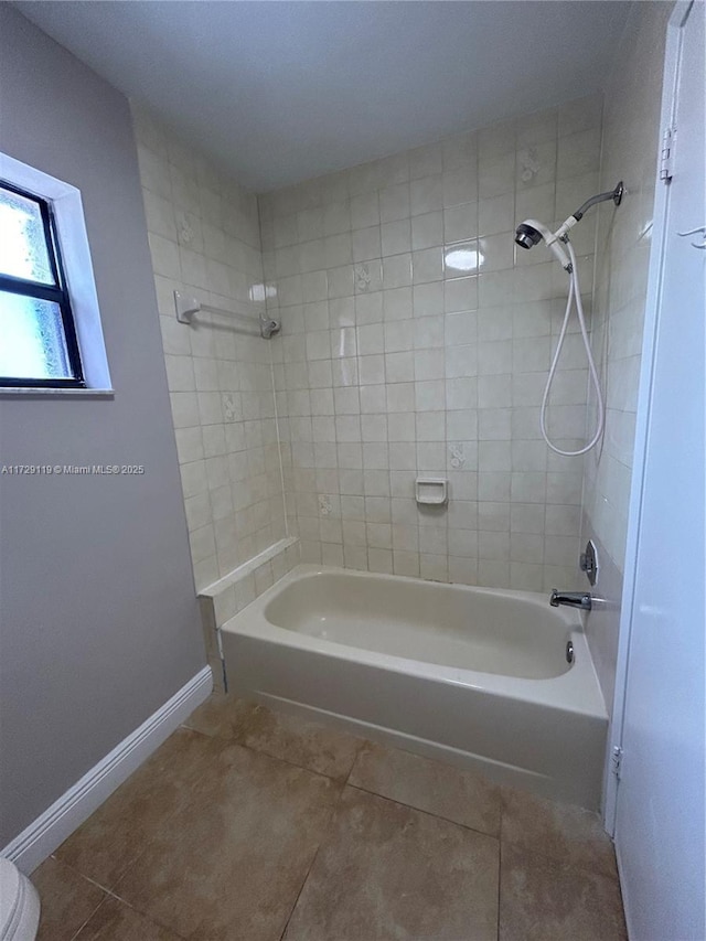 bathroom featuring toilet, tile patterned flooring, and tiled shower / bath combo