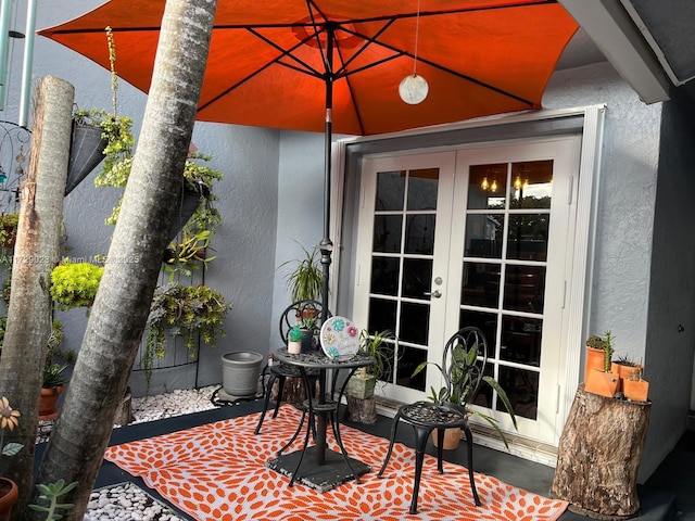 exterior space with french doors and stucco siding