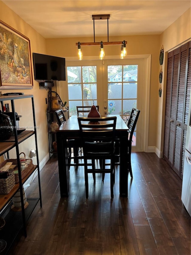 dining room featuring baseboards, dark wood-style floors, and plenty of natural light