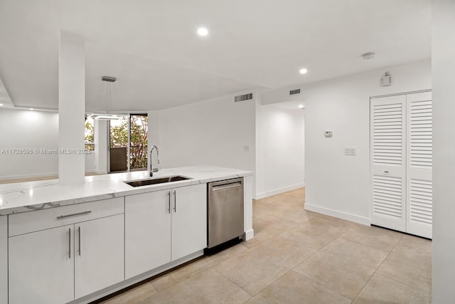 kitchen featuring stainless steel dishwasher, sink, white cabinetry, hanging light fixtures, and light stone counters