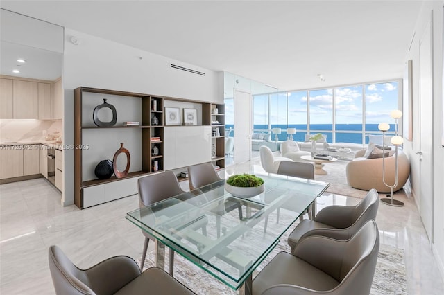 dining space with a water view and a wall of windows