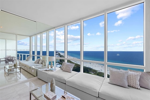 sunroom / solarium featuring a water view and a beach view