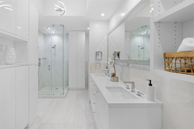 bathroom with a shower with door, vanity, and tasteful backsplash