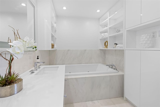 bathroom featuring vanity, tile patterned flooring, and a relaxing tiled tub