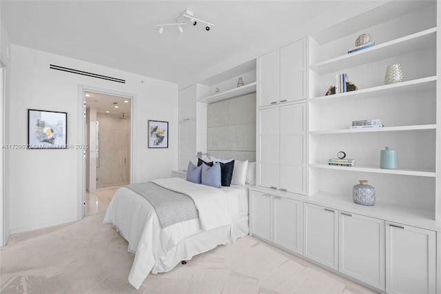 bedroom featuring ensuite bathroom and light carpet