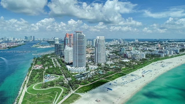 birds eye view of property with a water view and a beach view