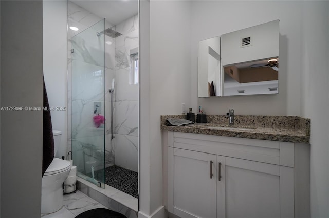 bathroom featuring vanity, a shower with shower door, and toilet