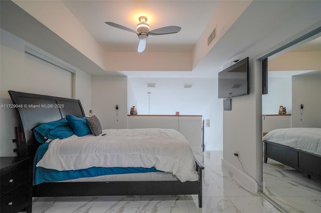 bedroom with a raised ceiling and ceiling fan