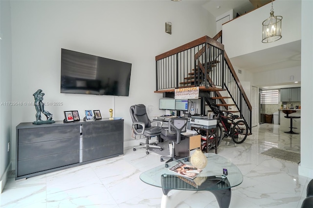 living room with an inviting chandelier and a towering ceiling