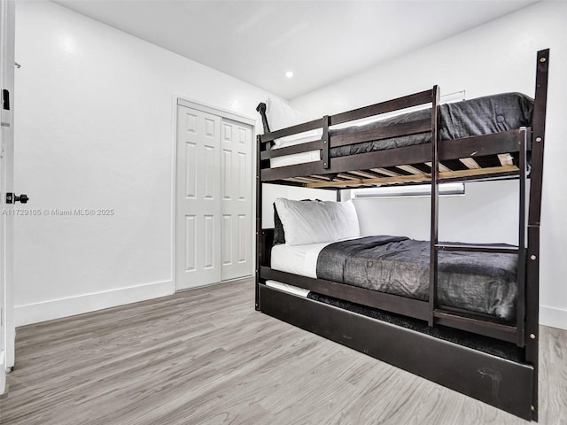 bedroom with wood-type flooring and a closet