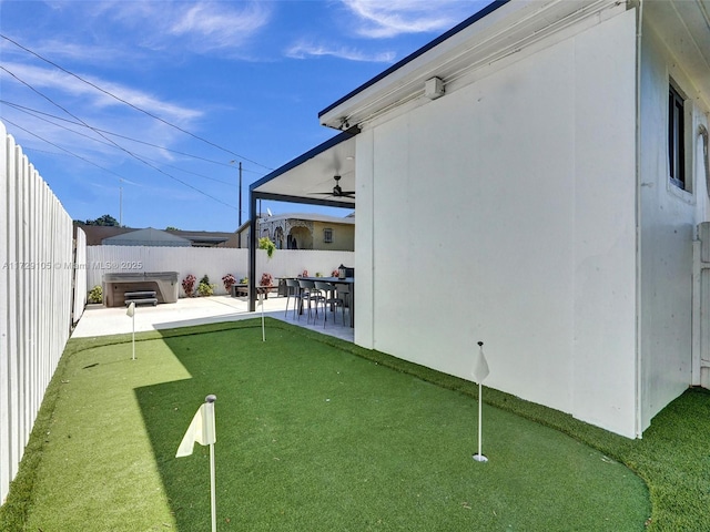 view of yard featuring a hot tub, a patio, and ceiling fan