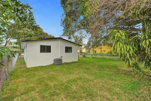 view of side of property with a yard and central air condition unit