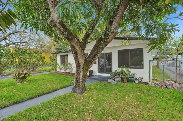 view of front of home with french doors and a front yard