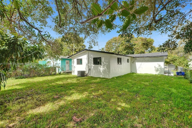 rear view of property featuring a yard and central AC