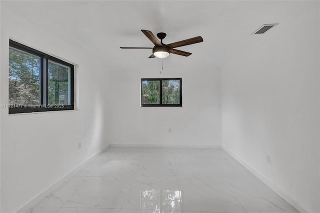 empty room featuring a healthy amount of sunlight and ceiling fan