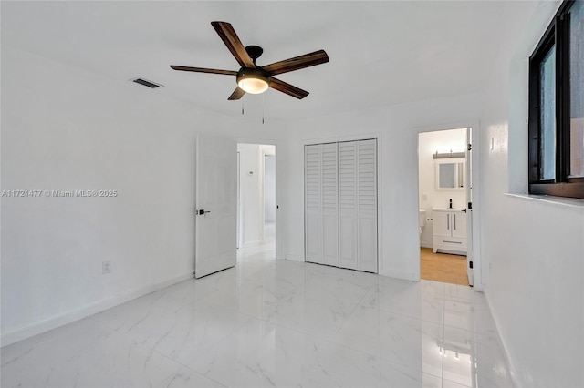 unfurnished bedroom featuring ceiling fan, a closet, and ensuite bathroom