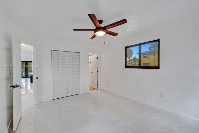 unfurnished bedroom with ceiling fan and a closet