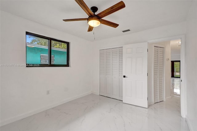 unfurnished bedroom with ceiling fan, multiple windows, and a closet