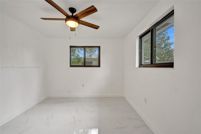 empty room featuring ceiling fan and plenty of natural light