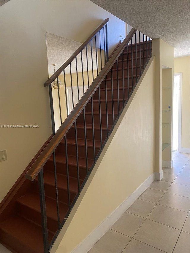 stairway featuring tile patterned flooring and a textured ceiling