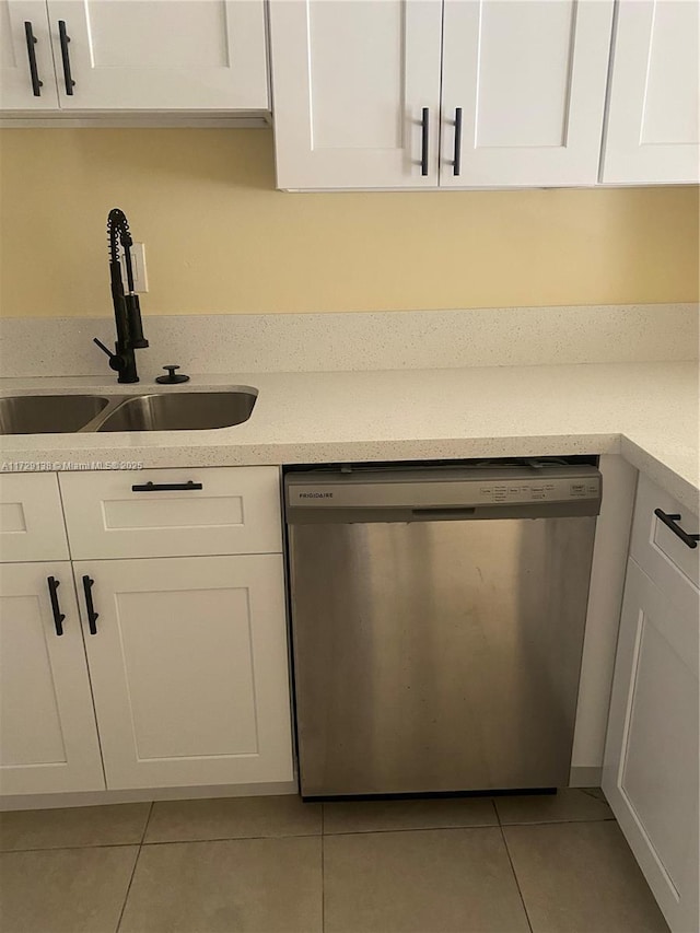 kitchen with stainless steel dishwasher, sink, and white cabinets