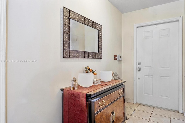 doorway to outside with light tile patterned flooring