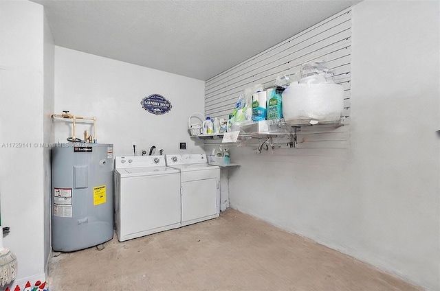 laundry room with washer and clothes dryer, water heater, and a textured ceiling