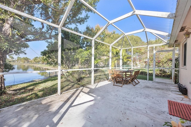 view of patio / terrace with glass enclosure and a water view