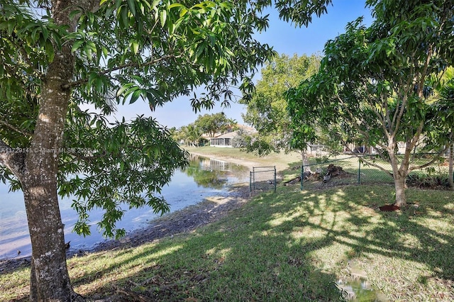 view of dock with a lawn and a water view