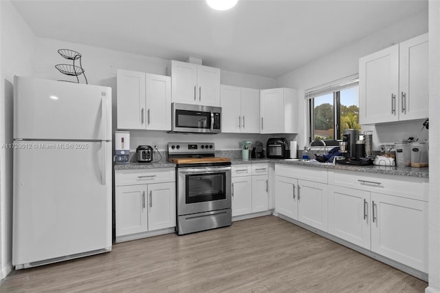 kitchen with white cabinetry, light hardwood / wood-style flooring, and stainless steel appliances