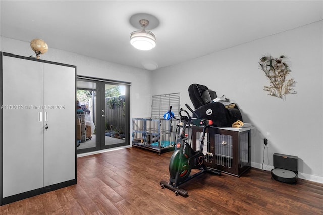 exercise room with dark wood-type flooring and french doors