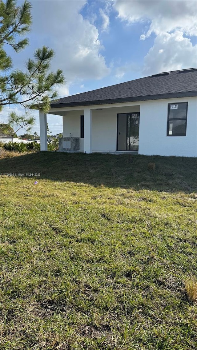 back of house featuring a lawn