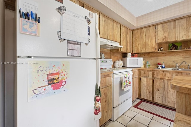 kitchen with light tile patterned floors, sink, and white appliances