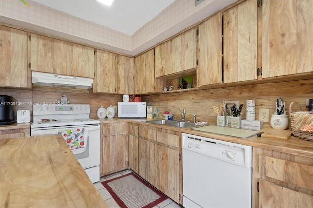 kitchen featuring wood counters, light tile patterned floors, light brown cabinets, white appliances, and sink