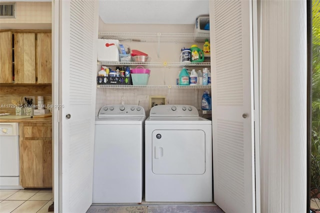 laundry room with light tile patterned floors and washing machine and clothes dryer