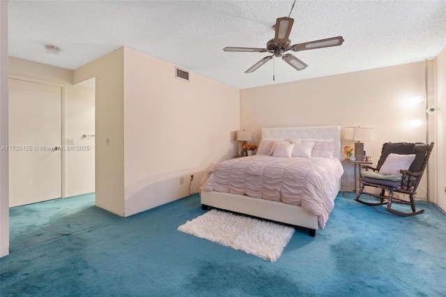 bedroom featuring ceiling fan, a textured ceiling, and carpet flooring