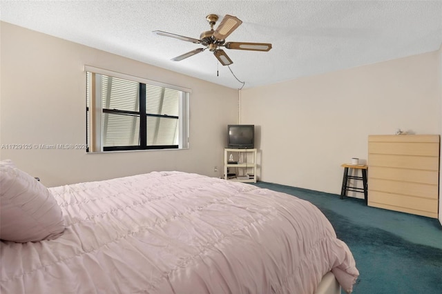 bedroom with ceiling fan, a textured ceiling, and dark colored carpet