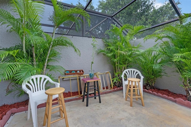 view of patio featuring glass enclosure