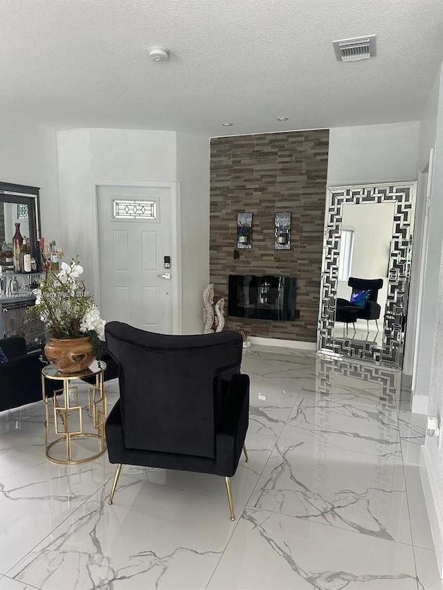 living room featuring a textured ceiling and a tiled fireplace