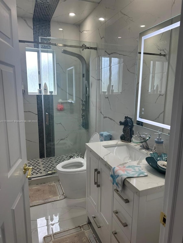 bathroom featuring a shower with shower door, vanity, and toilet