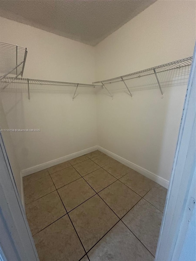 walk in closet with tile patterned flooring