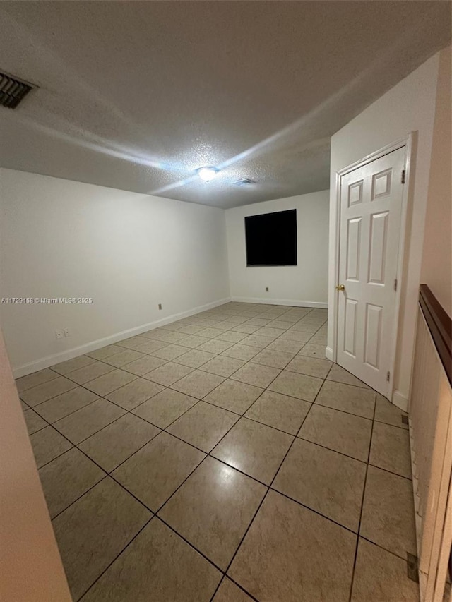 basement with light tile patterned flooring and a textured ceiling