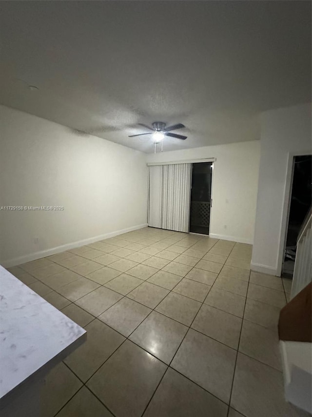 tiled spare room with ceiling fan