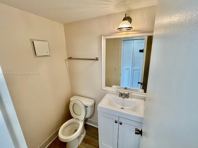 bathroom featuring toilet, vanity, and wood-type flooring