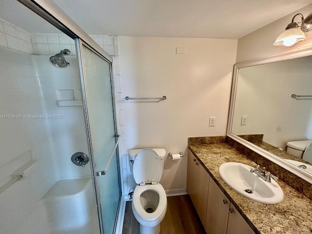 bathroom featuring walk in shower, vanity, toilet, and hardwood / wood-style floors