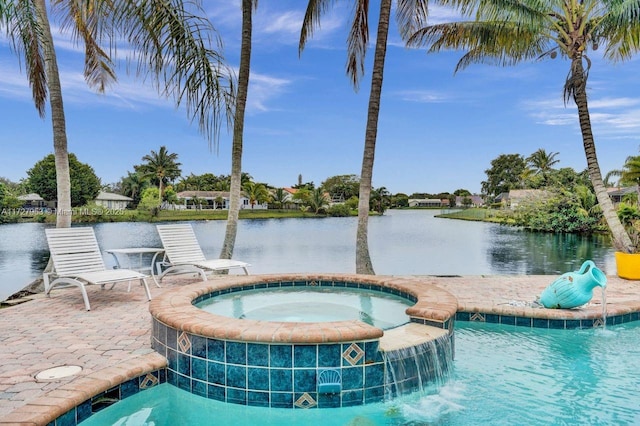 view of swimming pool with pool water feature, an in ground hot tub, a patio area, and a water view