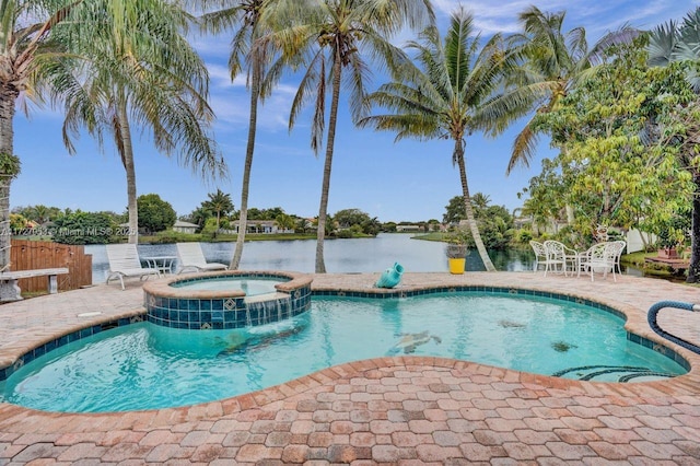 view of pool featuring an in ground hot tub, a water view, and a patio